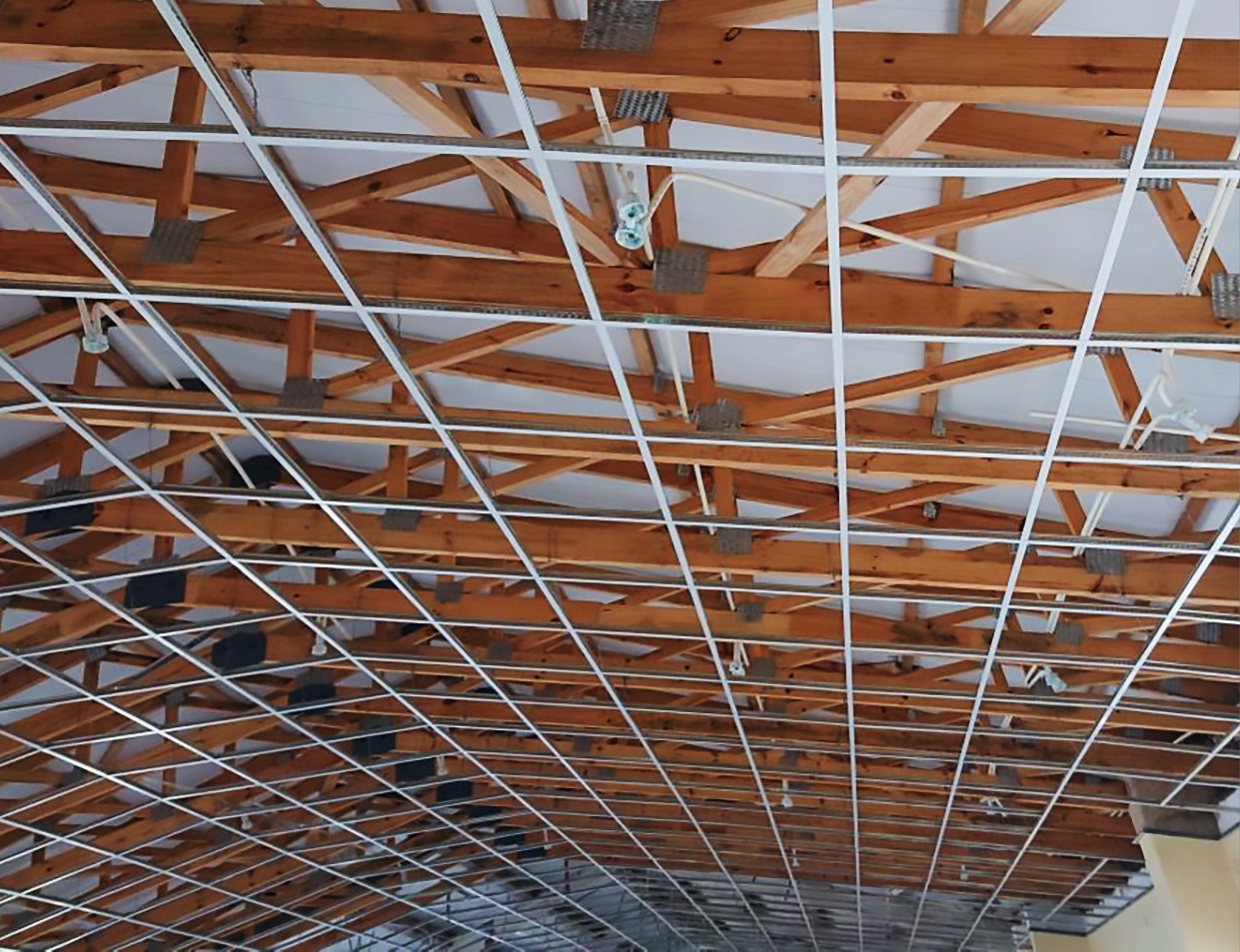 Ceiling grid being fitted under timber trusses